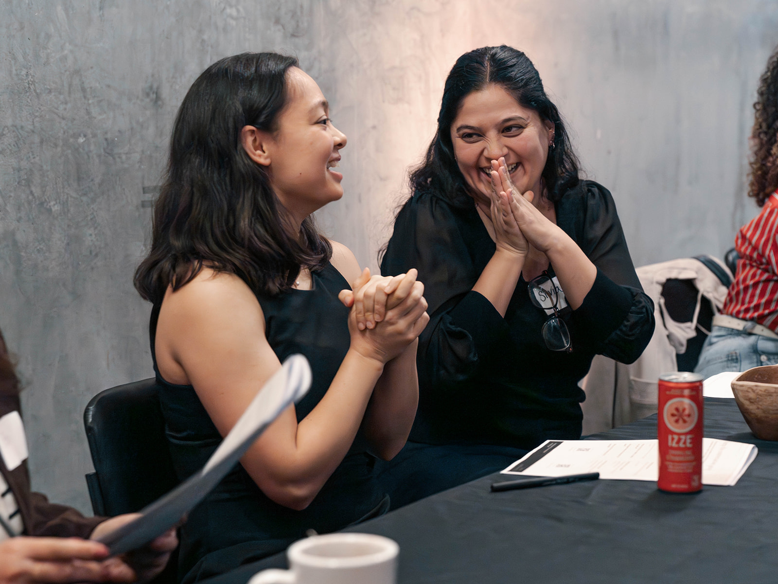 Two women laughing together during an Airaea leadership conversation